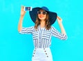 Cool girl is taking a picture on a smartphone wearing a straw hat Royalty Free Stock Photo