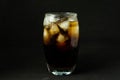 A cool glass of cola drink with ice, bubbles and fizz. Cola in glass with ice cubes isolated on dark background Royalty Free Stock Photo