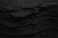 Cool greyscale background of black sand surface