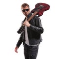 Cool guitarist in black leather jacket posing with his guitar