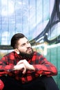 Cool guy with beard and piercings sitting outdoors Royalty Free Stock Photo