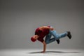 Cool guy breakdancer dancing lower break dance on the floor isolated on gray background. Break dance lessons Royalty Free Stock Photo