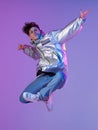 Cool guy dancing contemporary dance in studio. Neon light background. Acrobatic bboy dancer. Break dance lessons. Royalty Free Stock Photo