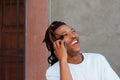 Cool guy with dreadlocks laughing and talking on phone Royalty Free Stock Photo