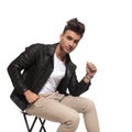 Cool guy with nice hair style is sitting on a chair