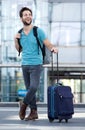 Cool guy smiling with bags at airport Royalty Free Stock Photo