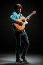 Cool guy standing with guitar on dark background Royalty Free Stock Photo