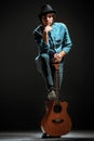 Cool guy standing with guitar on dark background Royalty Free Stock Photo