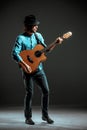 Cool guy standing with guitar on dark background Royalty Free Stock Photo