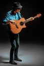 Cool guy standing with guitar on dark background Royalty Free Stock Photo