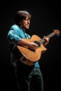 Cool guy standing with guitar on dark background Royalty Free Stock Photo