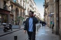 cool guy wearing sunglasses and jacket walking down the street Royalty Free Stock Photo