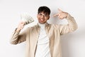 Cool handsome guy show-off, pointing at dollar bills and smiling boastful, making money, standing on white background Royalty Free Stock Photo
