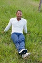 Cool handsome guy sitting on the grass Royalty Free Stock Photo