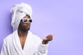 Portrait of young african man standing in towel and doing nail polish Royalty Free Stock Photo