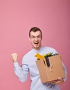 Cool happy man with a cardboard box with pens, plant and different things Royalty Free Stock Photo
