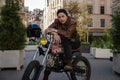 Cool hipster biker with old fashioned motorcyle in city