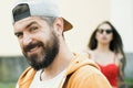 Cool hipster. Brutal man with long beard and mustache. Hipster street fashion. Attractive guy in front of girl Royalty Free Stock Photo