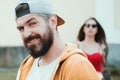 Cool hipster. Brutal man with long beard and mustache. Hipster street fashion. Attractive guy in front of girl Royalty Free Stock Photo