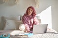 Cool hipster teen girl with pink hair sit on bed showing tongue with piercing. Royalty Free Stock Photo