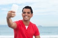 Cool latin guy in red shirt making selfie with phone Royalty Free Stock Photo