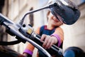 Cool little biker child girl looking in the rearview mirror and having fun on fashioned motorcycle. Humorous photo Royalty Free Stock Photo