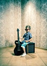 Cool little boy posing with electric guitar.