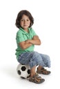 Cool little boy sitting on a soccer ball