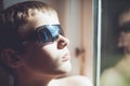 Cool looking child in sunglasses near window