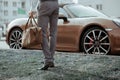 Cool man beautiful model outdoors, city style fashion. A handsome man model walking in the city center next to some cars Royalty Free Stock Photo