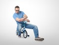 Cool man in a glamor glasses on children's bicycle Royalty Free Stock Photo