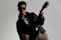 cool man in leather jacket playing guitar, making a show and posing Royalty Free Stock Photo