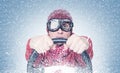 Cool man in red sweater scarf and hat with stylish goggles, drives a car in snowstorm with his hands on the steering wheel. Front Royalty Free Stock Photo