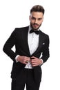 Cool modern man in tuxedo holds button Royalty Free Stock Photo