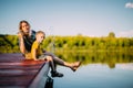 Cool mother and baby boy sitting on dock launch soap bubbles. Summer photography for blog or ad about family and travel