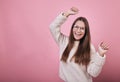 Cool nice girl in transparent glasses in a knitted sweater dancing and having fun