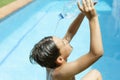 Cool off in the summer heat wave in the pool. young man splashing a bottle of water on his face. Concept of high temperatures in Royalty Free Stock Photo