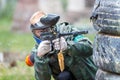 Cool paintball player shooting from marker outdoors Royalty Free Stock Photo
