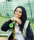 Cool pretty smiling afro-american happy young woman with skate board hanging aroung at foothball field Royalty Free Stock Photo