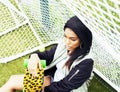 Cool pretty smiling afro-american happy young woman with skate board hanging aroung at foothball field, lifestyle people Royalty Free Stock Photo