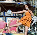 Cool real teenage girl with candy near carousels at amusement park walking, having fun Royalty Free Stock Photo