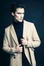 Cool real young man in coat on black background posing, lifestyle people concept Royalty Free Stock Photo