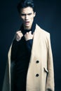 Cool real young man in coat on black background posing, lifestyle people concept Royalty Free Stock Photo