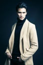 Cool real young man in coat on black background posing, lifestyle people concept Royalty Free Stock Photo