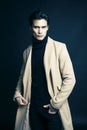 Cool real young man in coat on black background posing, lifestyle people concept Royalty Free Stock Photo