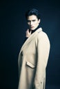 Cool real young man in coat on black background posing, lifestyle people concept Royalty Free Stock Photo