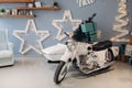 Cool retro motorcycle with Christmas presents. Motorcycle with gifts in decorated room. Royalty Free Stock Photo