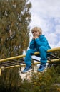 cool schoolboy in a trendy bright blue tracksuit sits on the stairs of the sports ground