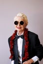 Cool senior woman in tuxedo and sunglasses at the party.