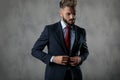 Cool young businessman buttoning his suit and looks down Royalty Free Stock Photo